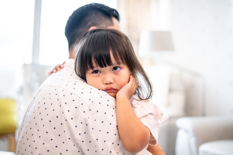 crying child being held by parent