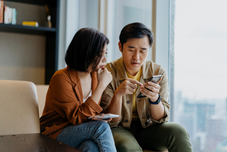 couple in a serious discussion while looking at their phones