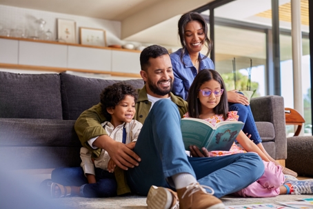 happy family reading a book in the living room